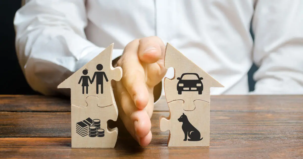 Male hand separating puzzle house with images of property, children & pets, representing property division. MBH Fort Worth | Family Law