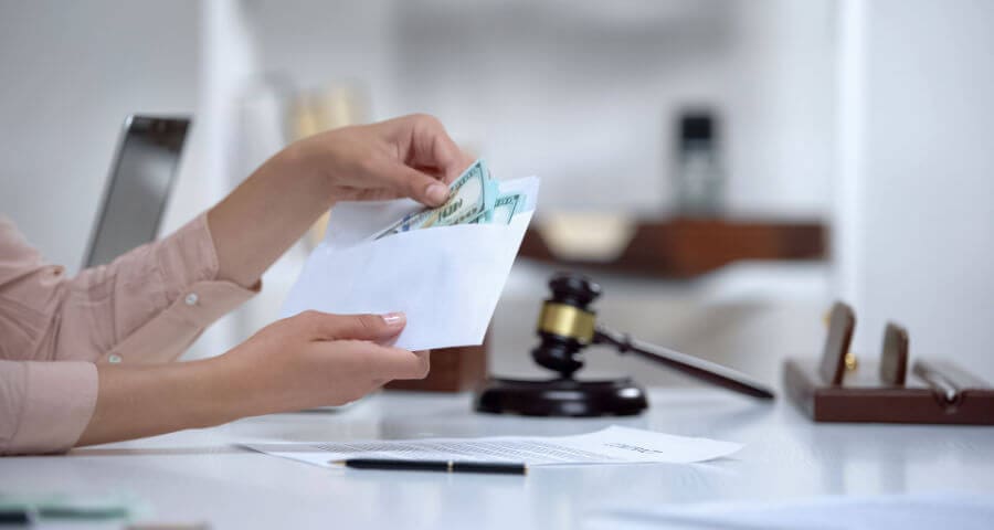 spouse holding envelope with alimony payment, a divorce lawyer can help, call Mims Ballew Hollingsworth | Family Law for help